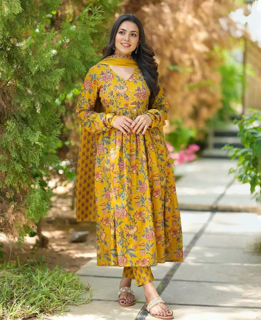 Embrace timeless elegance in this mustard yellow floral Anarkali cotton suit set adorned with charming floral prints. Tailored in breathable cotton fabric, this 3-piece ensemble includes a flared kurta, matching straight pants, and a printed dupatta – ideal for summer brunches, festive celebrations, or ethnic day wear.