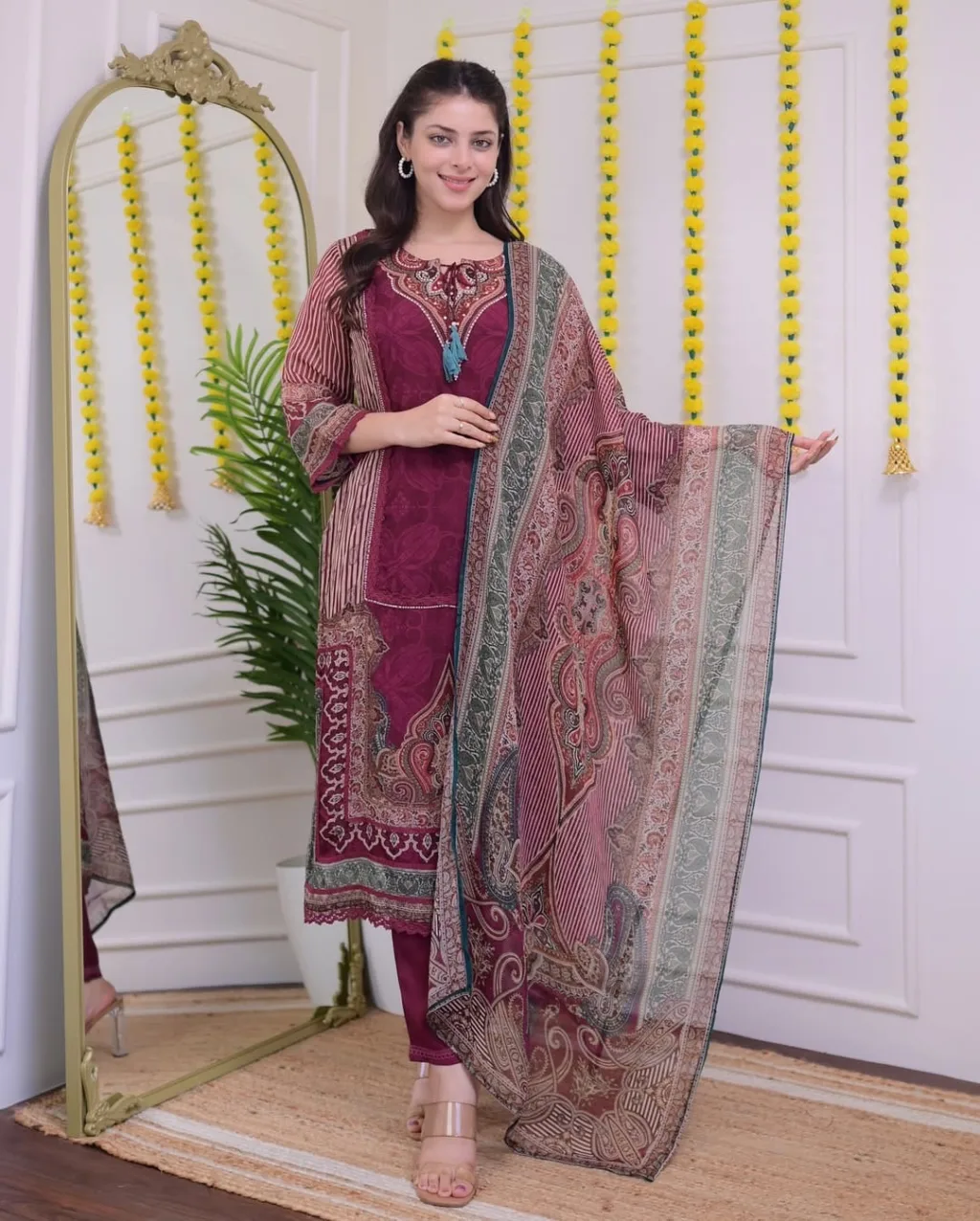 This elegant Maroon Printed Embroidered Suit Set is a harmonious blend of traditional print and light embroidery, tailored from comfortable muslin fabric. With its classic neckline and vertical sleeve stripes, it’s ideal for festive occasions or office wear. Includes a straight kurta, matching pants, and printed dupatta for a complete ethnic look.