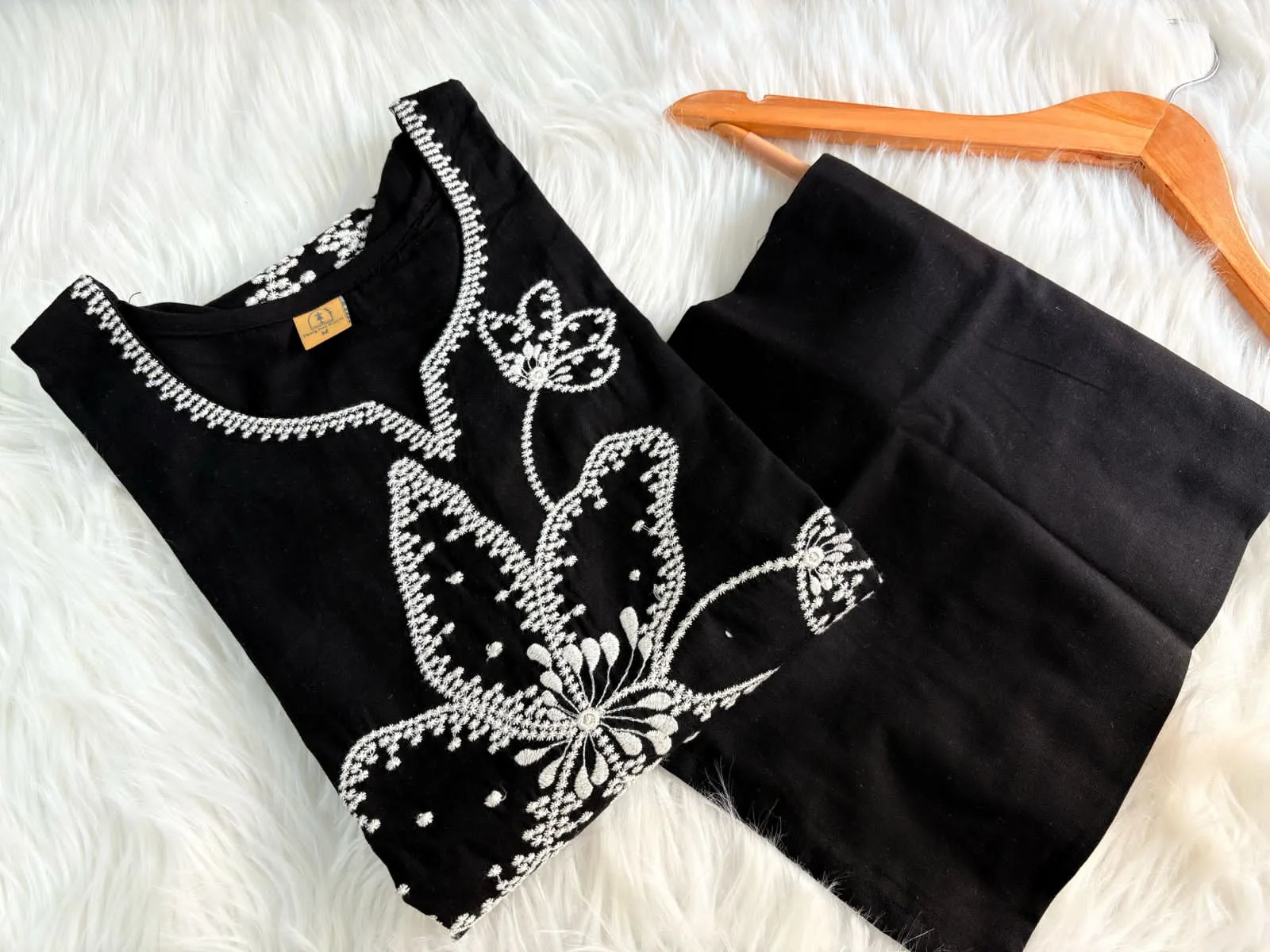 Black cotton suit set with white floral thread embroidery – elegant stitched ethnic wear for women.