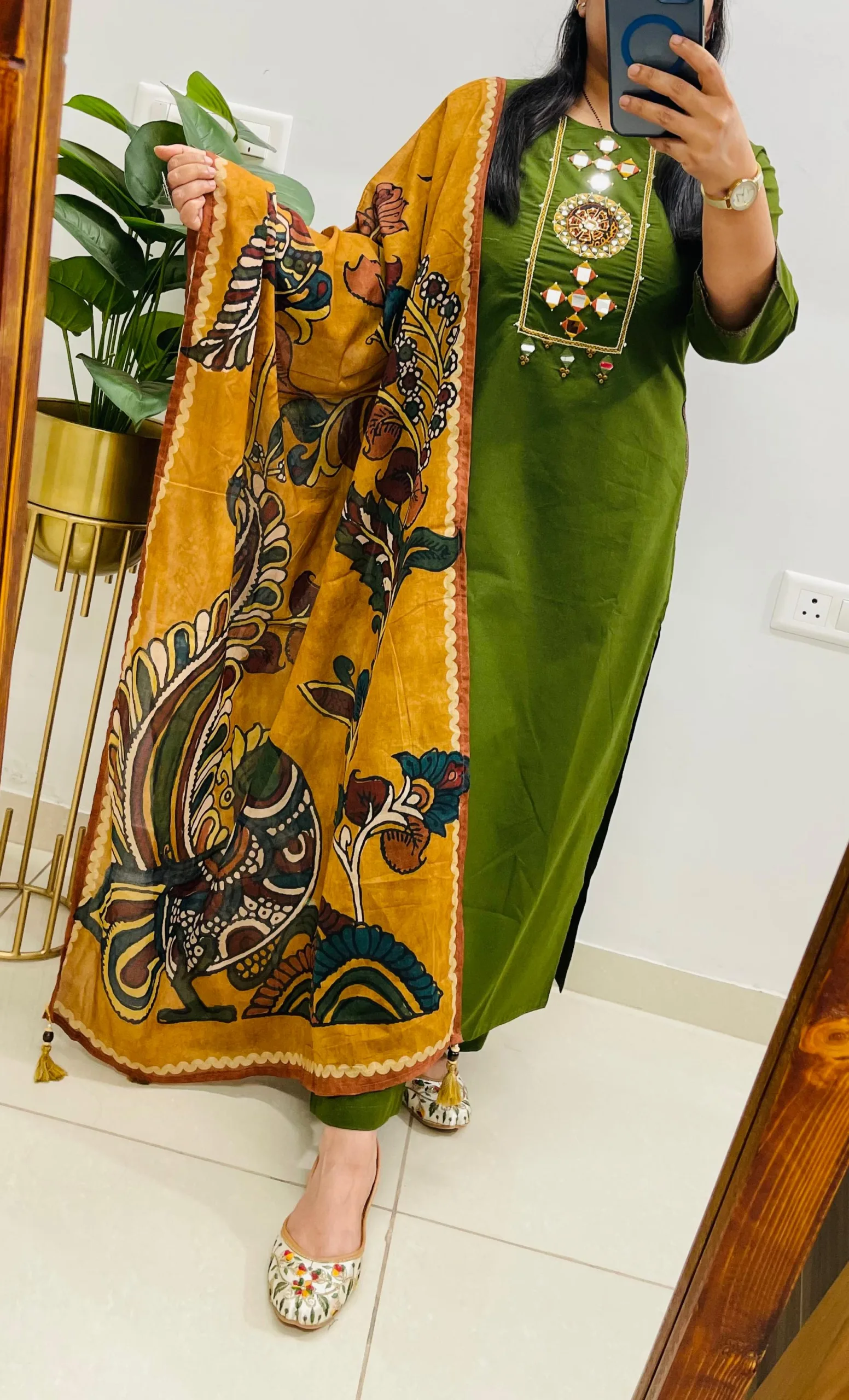 A woman in a mirror selfie wearing a "WhatsApp Image 2026-05-11 at 9.07.30 PM.jpeg" featuring a mehendi green Dhabu cotton kurti with a Kutch embroidered yoke and a mustard-toned printed dupatta.